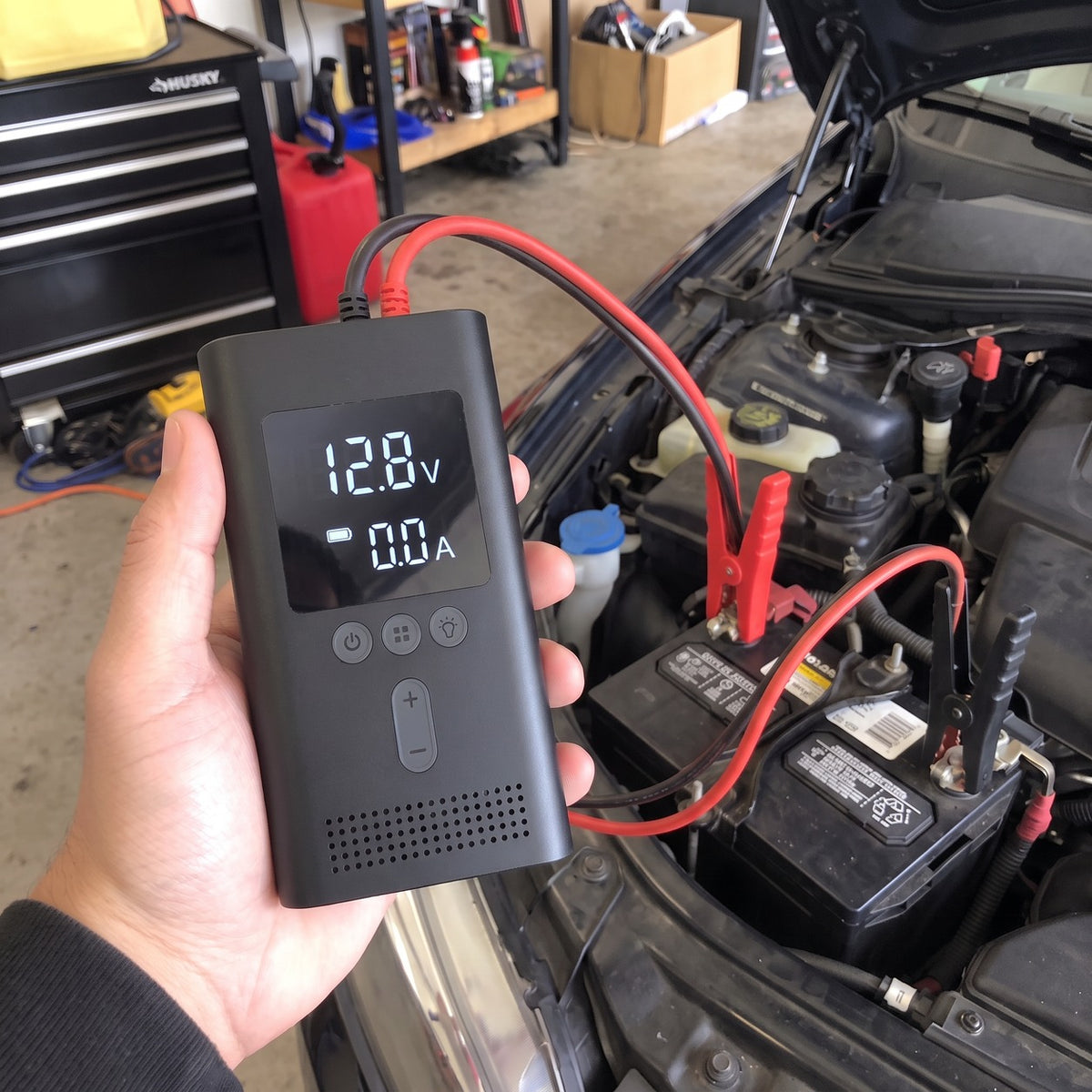 Crankbox clamped to a car battery under the hood, display lit